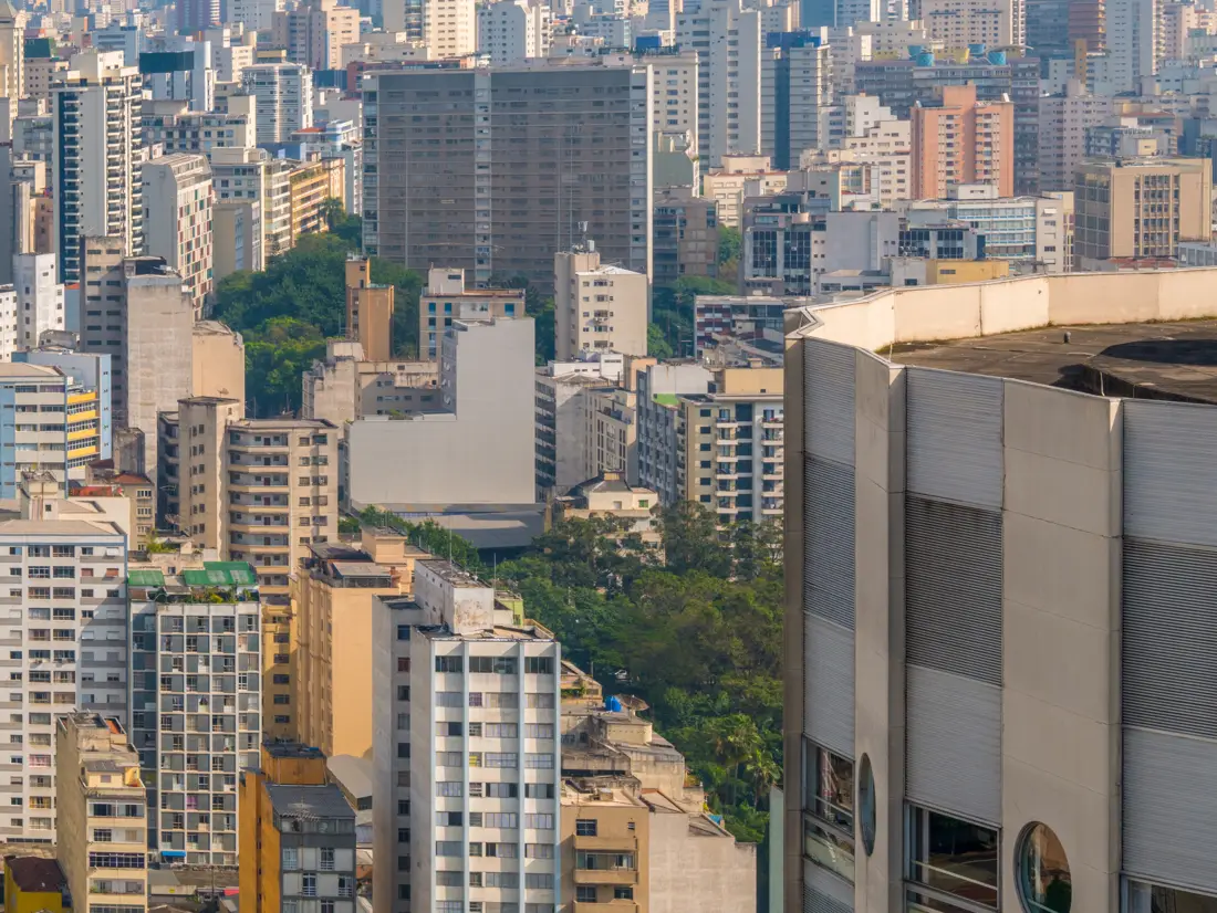 Décimo andar: prédios do bairro e copas de árvores à altura da janela.