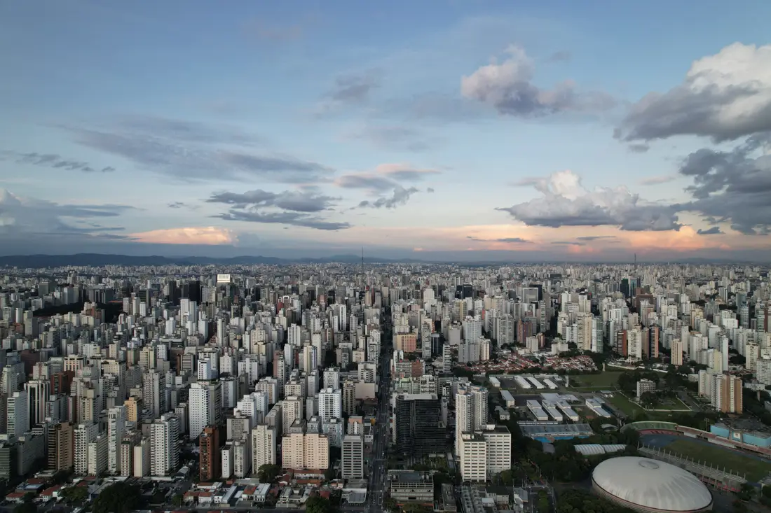 Vigésimo segundo andar: a cidade inteira até o horizonte sob céu com nuvens.